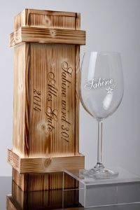 Ein graviertes Weinglas in einer schicken Holzkiste